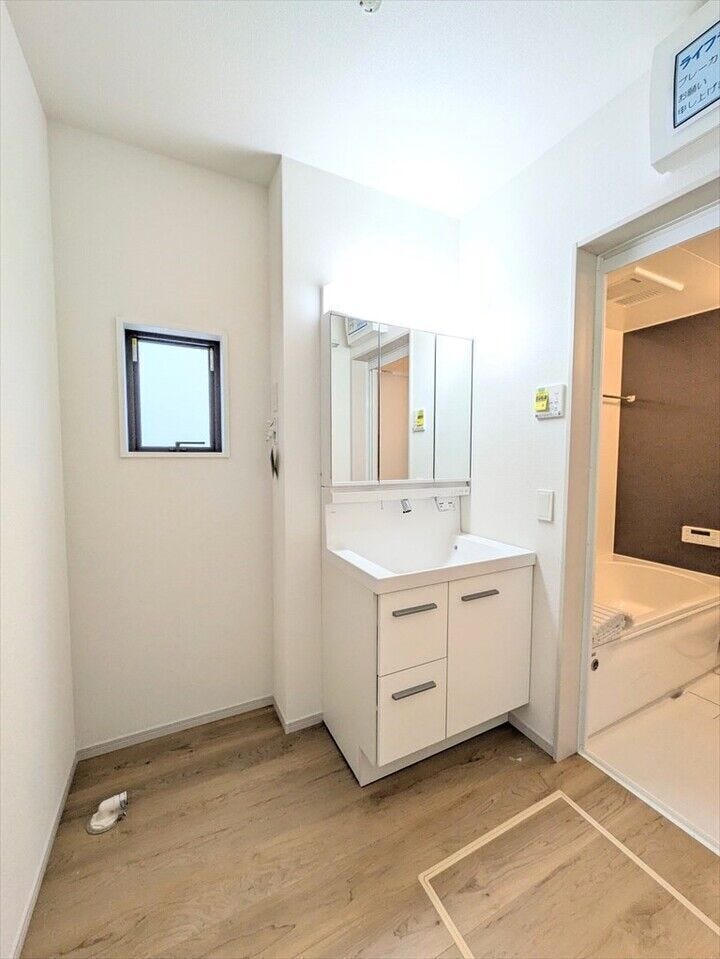 【同社施工例】窓付きの明るいランドリールーム。洗面台にはハンドシャワーがついているので、朝の身支度もラクラク!