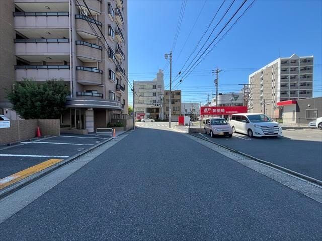 マンション西側前面道路です。駐車場の出入口に面しています。道路の向かいに「名古屋弥富郵便局」があります。