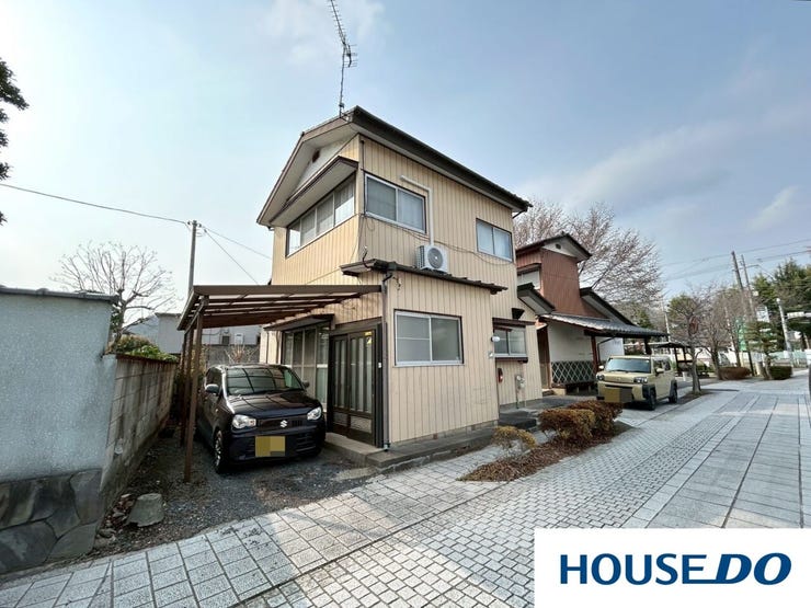 屋根付きの駐車スペースを完備した、生活に便利な2階建て住宅です。前面道路はゆとりがあり、お車の出し入れもスムーズ。閑静な住宅街に位置し、穏やかな新生活をスタートさせるのに最適な住環境です。