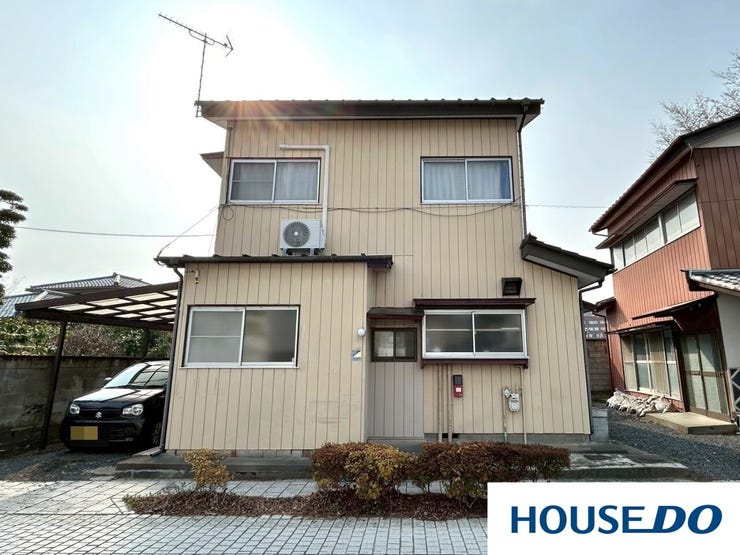 温かみのあるベージュの外壁が印象的な2階建て住宅です。カーポート付きの駐車スペースがあり、雨の日のお出かけも安心。前面道路は平坦で、陽当たりも良く開放感たっぷり。落ち着いた住環境も魅力です。