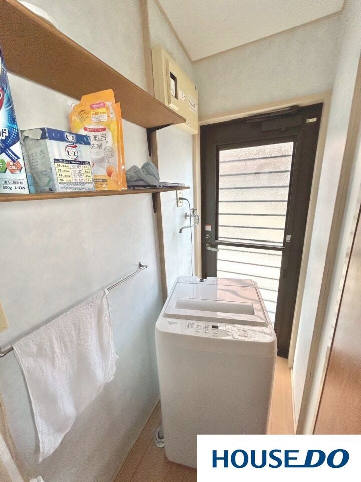 勝手口から直接外へ出られる便利な家事動線が魅力です。洗濯機置き場の上部には備え付けの棚があり、洗剤などの小物もスッキリ収納可能。明るい光が差し込む空間で、毎日の洗濯仕事もスムーズにこなせます。