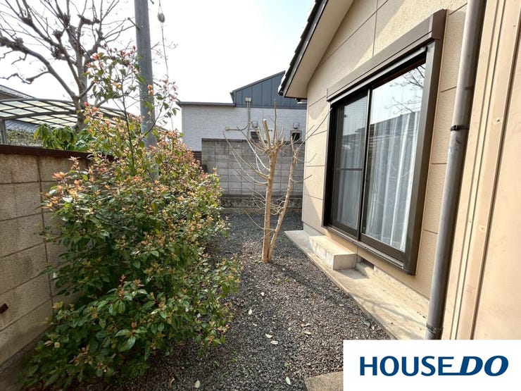 砂利敷きでお手入れが簡単な専用庭です。掃き出し窓からすぐに出入りでき、ガーデニングや物干しスペースとしても重宝します。周囲は塀で囲まれており、プライバシーを確保しながら安心して活用できる空間です。