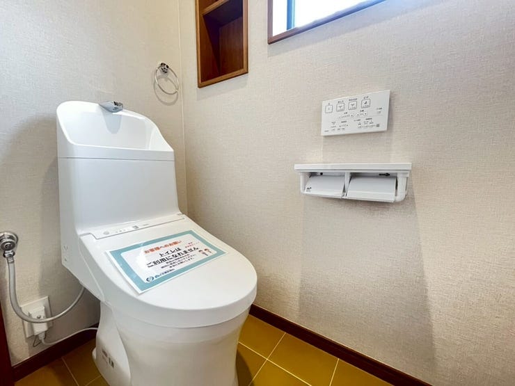 白を基調とした清潔感のあるトイレ空間です。温水洗浄便座や、小物の整理に便利な埋込式の収納棚が完備されており、機能面が充実しています。