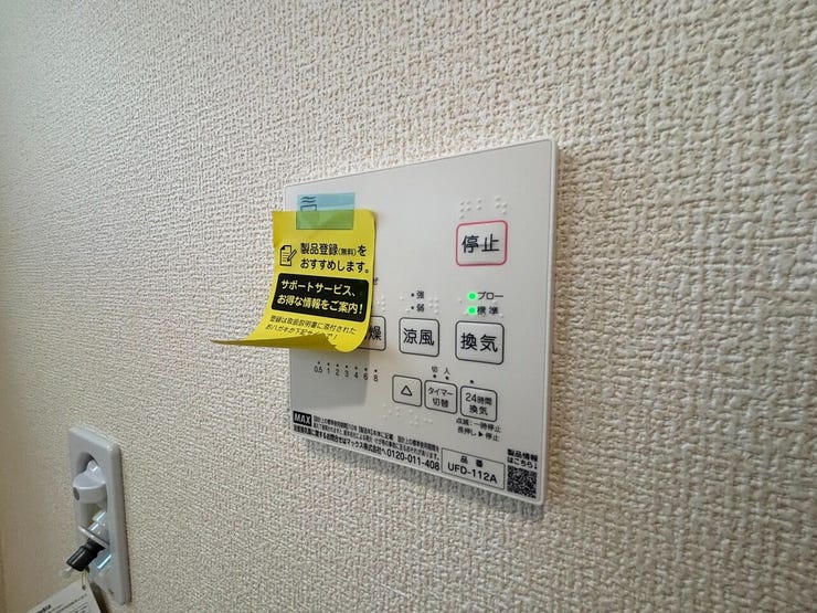 壁面に浴室換気暖房乾燥機のリモコンが設置されています。天候に左右されない洗濯物の乾燥や、季節に応じた快適な入浴、浴室の湿気対策に対応する設備です。