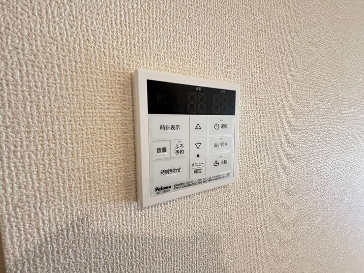 壁面に給湯器のリモコンが設置されています。浴室へ移動することなく、ボタン一つでお風呂の自動お湯張りや追い焚きなどの操作が可能です。通話機能も備わっております。