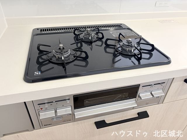 複数の調理を同時に進められる三口コンロと、便利なグリルを備えた機能的なキッチン。