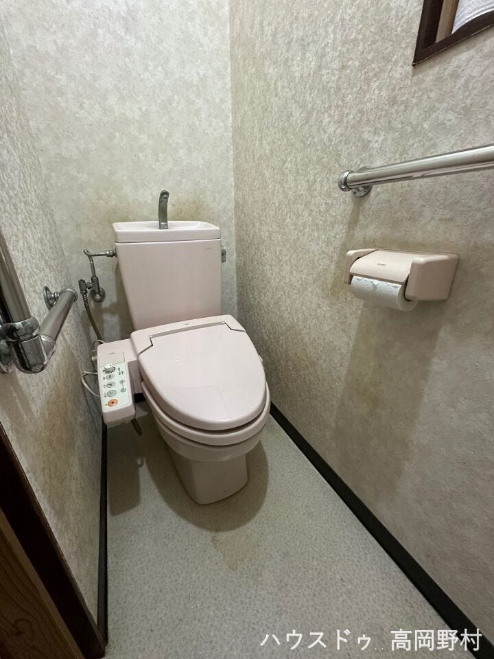 温水洗浄機能付きのトイレ。手すりも設置されており、安心してお使いいただけます。