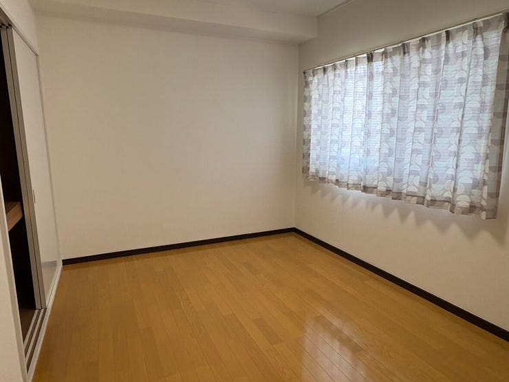大きな窓から柔らかな光が差し込む洋室です。フローリング仕様でお掃除がしやすく、寝室や子ども部屋など多目的に使えます。白壁に木目が映えるシンプルな内装でお好みの家具を自由にレイアウトできそうです。