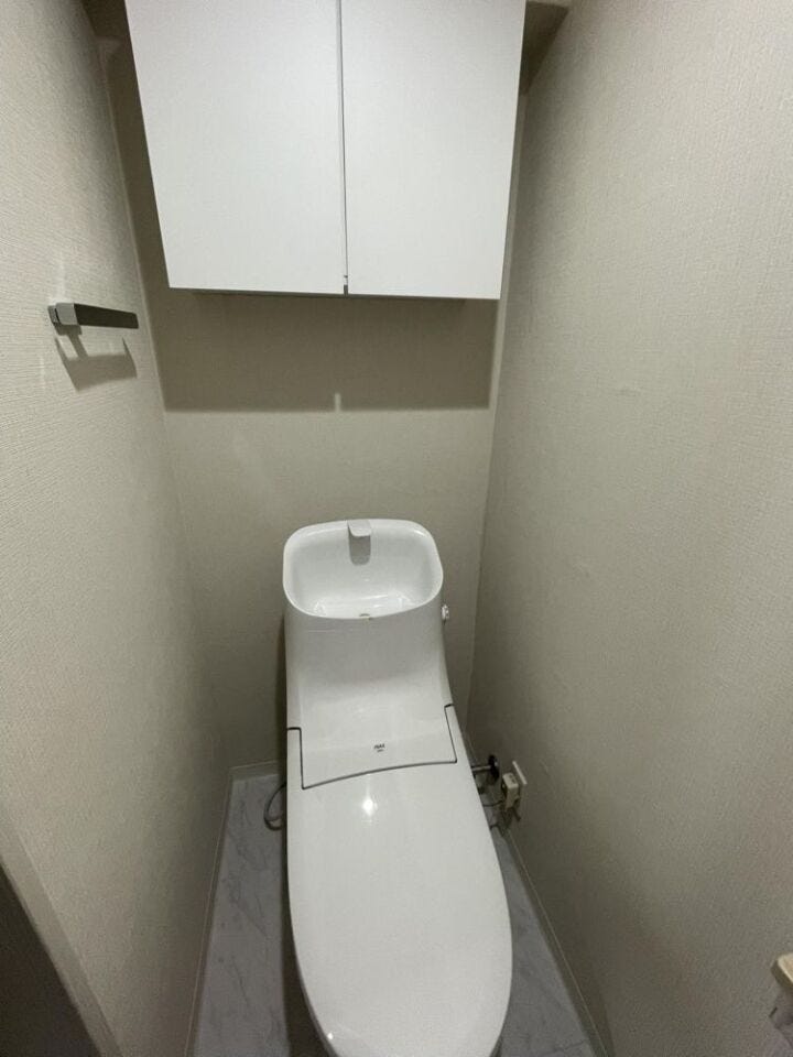 温水洗浄便座付きトイレ。上部収納もあり、すっきりとした空間を保てます。