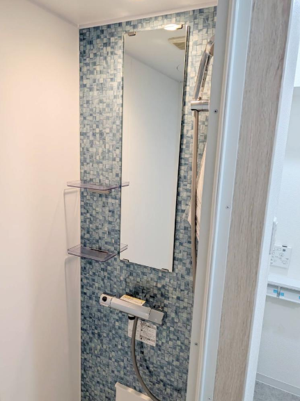 ブルーのアクセントクロスがおしゃれな洗面スペース。ホテルライクな雰囲気