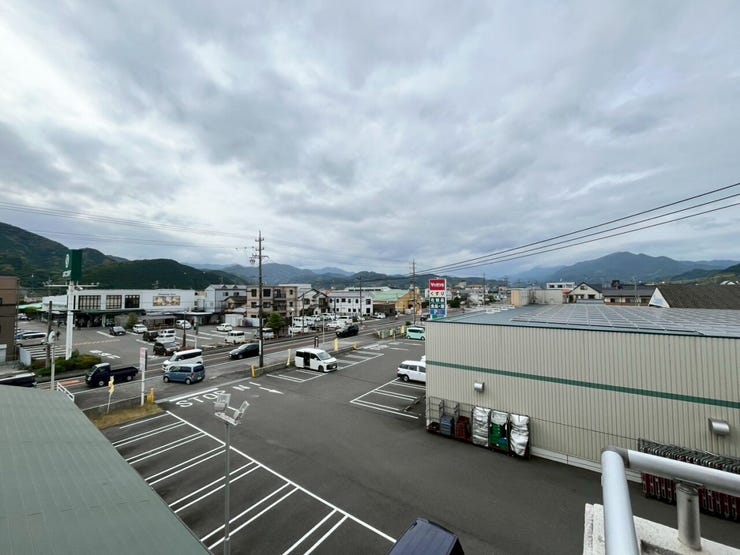 物件からの眺望です。前面には視界を遮るような高層の建物が隣接しておらず、広く開けた景色が広がっています。遠方には連なる山並みを望むことができ、周囲の街並みと自然の風景を視認できる立地条件です。