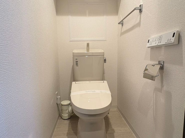 白を基調とした、清潔感あふれる温水洗浄機能付きトイレです。壁面には便利なリモコンパネルとタオル掛けがすっきりと配置されています。毎日の生活に欠かせない場所だからこそ、気持ちよく使える空間が嬉しいです。