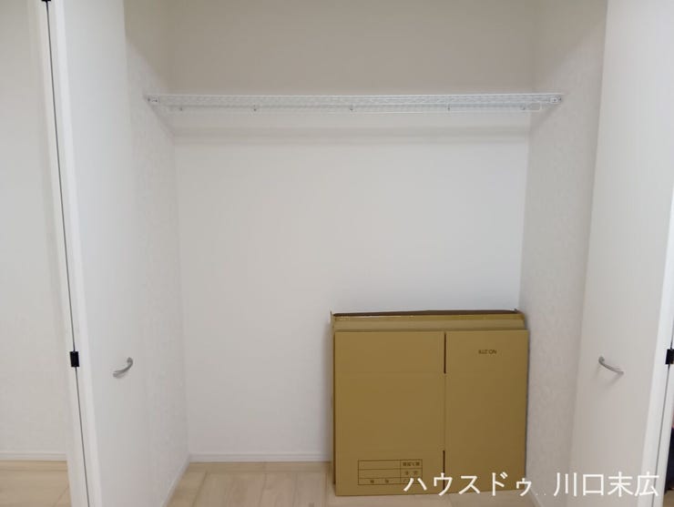 機能的なシステム収納を備えたクローゼット。ハンガーパイプや枕棚が設置されており、洋服から小物まで整理整頓しやすく、スマートな収納を実現します。