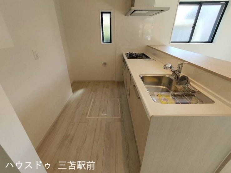 《キッチン》木目の天井とカウンターが調和した、温かみのある上質なキッチン空間。