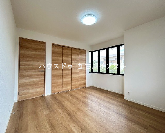 温かみのある木目調の建具とフローリングが調和する、明るい2階の洋室です。出窓風の大きな窓から心地よい光が差し込みます。備え付けのクローゼットもあり、お部屋をすっきりと広くお使いいただけます。
