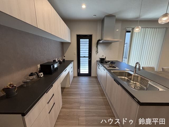 リビングを見渡せる開放的なオープンキッチンで、カップボードも備えているのでキッチン周りをすっきり保てるのがいいですね。