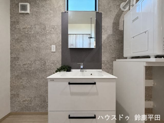 洗面下に収納を備え、洗剤や日用品などを整理できます。隣には洗濯機を置くスペースもあり、家事動線も良好です。