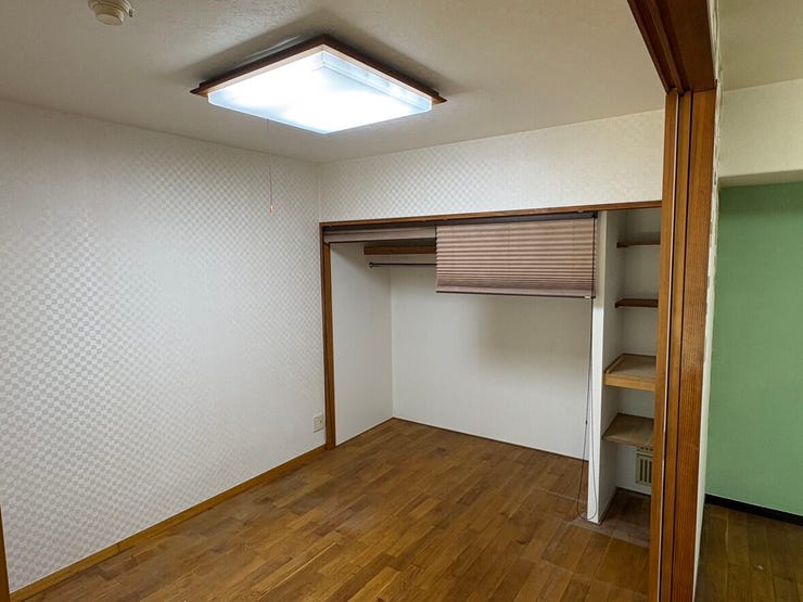 木目調のフレームが優しい印象を与える照明と、使い勝手の良いオープン収納がある洋室です。可動棚にはお気に入りの小物を並べて。自分らしいレイアウトを楽しみながら、穏やかな時間をゆったりと過ごせそうですね。
