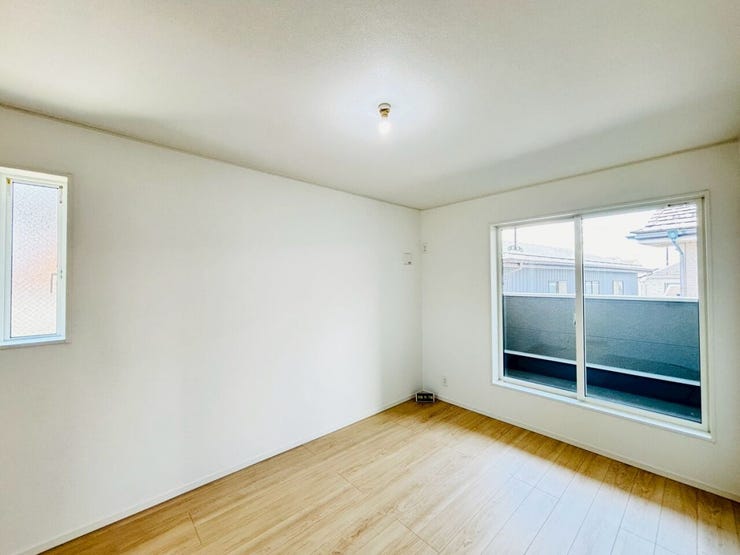 大きな掃き出し窓から差し込む陽光が気持ちいい洋室。木の温もりを感じるフローリングと白い壁が、開放的な空間を演出します。自分好みのインテリアで、快適なプライベートルームを作り上げてください。