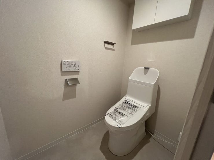 新規交換のトイレは快適な温水洗浄便座付き!清潔感溢れる空間で、日々のお手入れもラクラク。吊戸棚付きでトイレットペーパーなどのストックもすっきり収納できます。