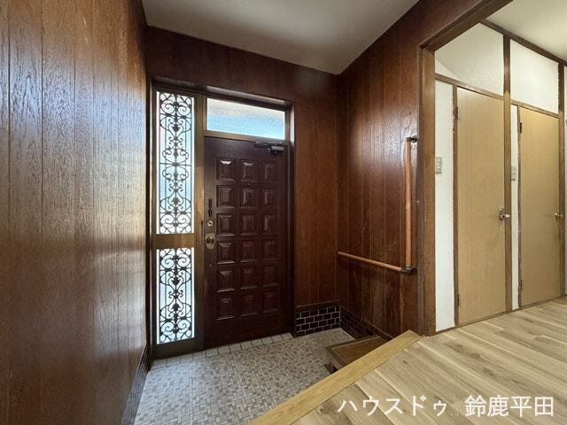 木目調の落ち着いた雰囲気の玄関です。手すりと腰掛けのスペースを備え、子供や高齢者の方も安心できますね。