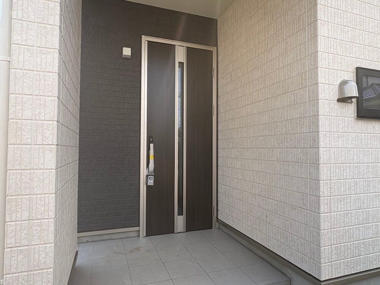 落ち着いたダークカラーの玄関ドアが、住まいの顔として上質な佇まいを演出します。ゆとりあるポーチは帰宅時に一息つけるスペースとなり、家族を温かく迎え入れる心地よい空間です。