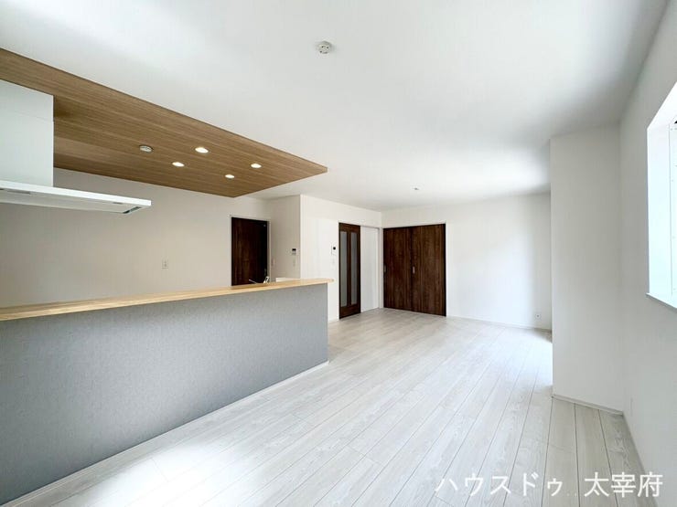 【リビング】
キッチン部分の上部に木目調の下がり天井が採用されており、埋め込み式のダウンライトと合わせて、空間全体に立体感と温かみのある雰囲気を演出しています。