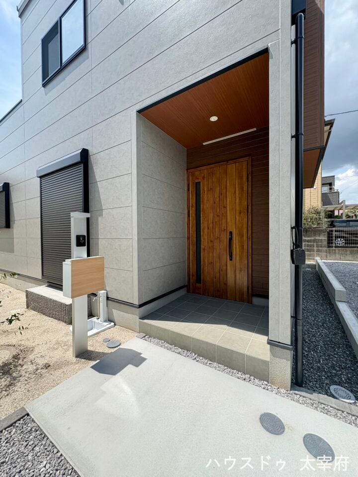 屋根付きのゆとりある玄関アプローチで、雨の日も安心して出入り可能です。重厚感のある玄関扉で上質な印象を与えます。