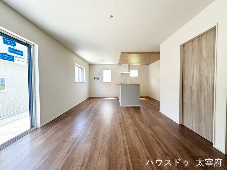 【リビング】
リビングからキッチン方向を見渡せる広々とした間取りで、家具の配置がしやすく、家族が自然と集まりやすい空間です。温かみのあるブラウン系の木目調床材が使われており、落ち着いたデザインです。