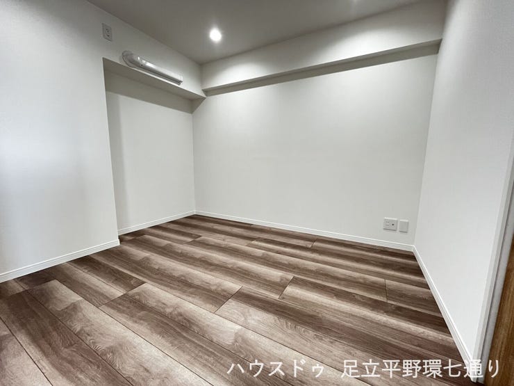 落ち着いた木目調フローリングが印象的な、清潔感のある居室空間です。
