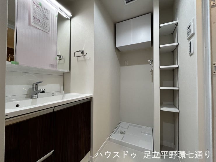 洗濯機置場の上部収納と可動棚付きで、洗剤やタオル類も整理しやすい機能的な空間です。