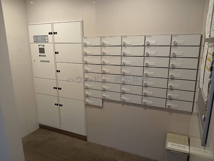 管理人室の奥に郵便受けと宅配BOXあり