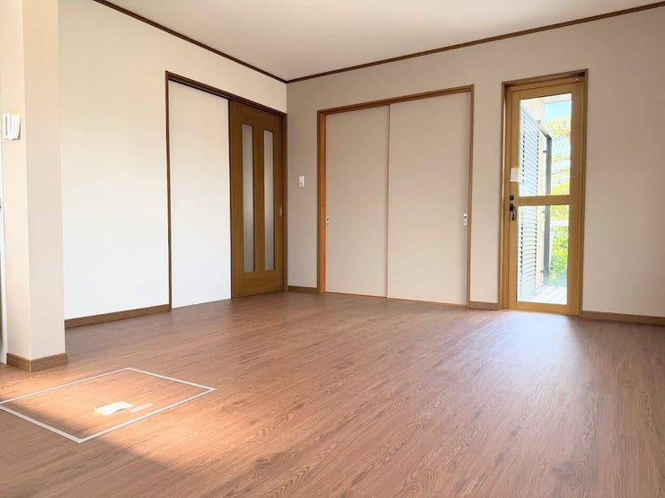 木目調のフローリングと明るい木枠の建具が調和した、開放的で清潔感のあるお部屋です。