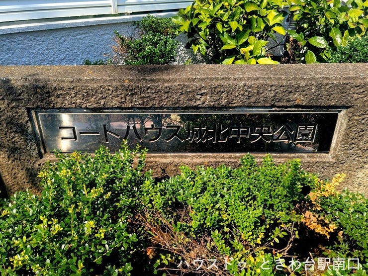 「コートハウス城北中央公園」の銘板が設置された植栽スペース。管理の行き届いたエントランスまわりです。