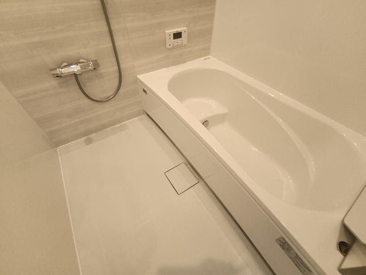 白い浴槽と落ち着いたグレーの壁が上品な浴室です。ゆったり浸かれる広さで、シャワー設備も使いやすく、ホテルのような心地よさを演出してくれます。