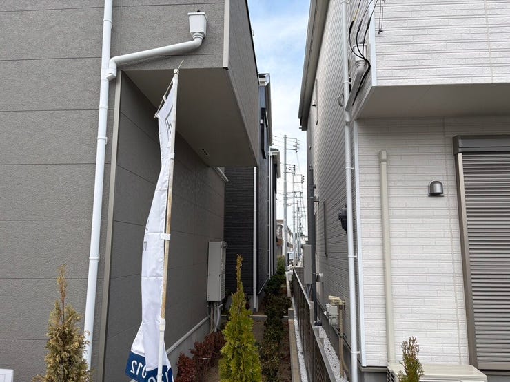 隣地との境界部分には、グリーンの植栽がバランスよく配置されています。建物と道路の間に程よいゆとりがあり、敷地全体がすっきりと整った印象です。爽やかな風が通り抜ける、開放感のある住環境が広がります。