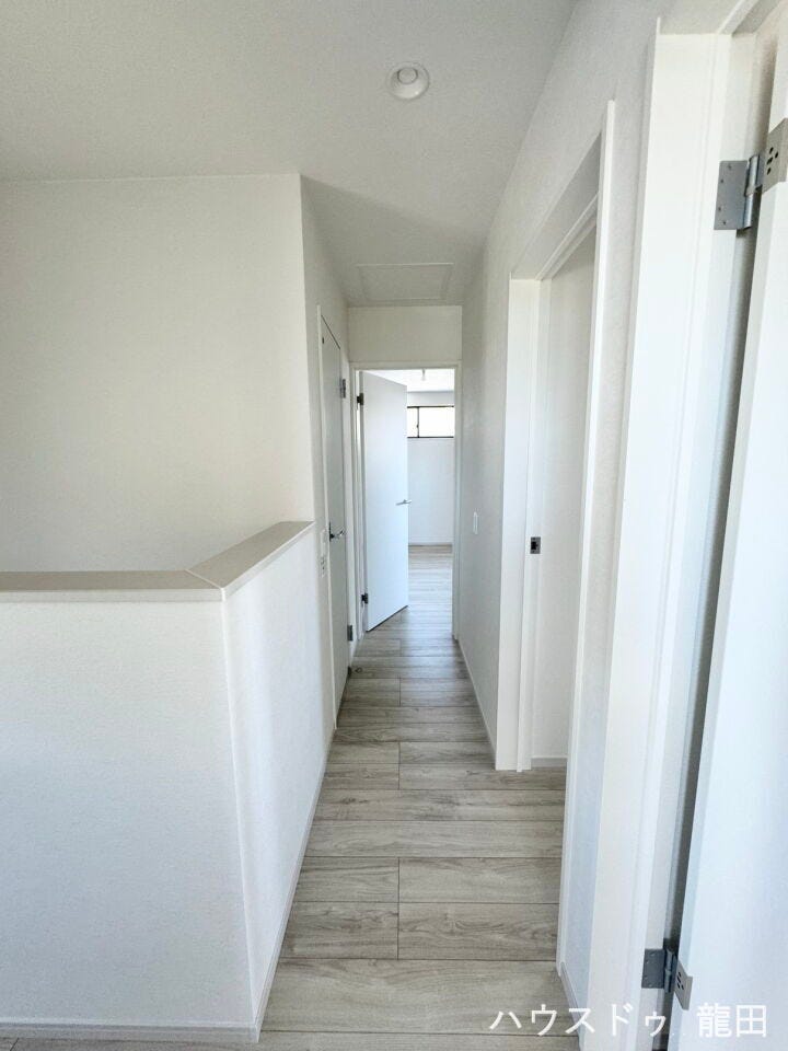 白を基調とした明るい廊下。奥の窓から優しい光が差し込み、毎日のお部屋間の移動も心地よい空間です。