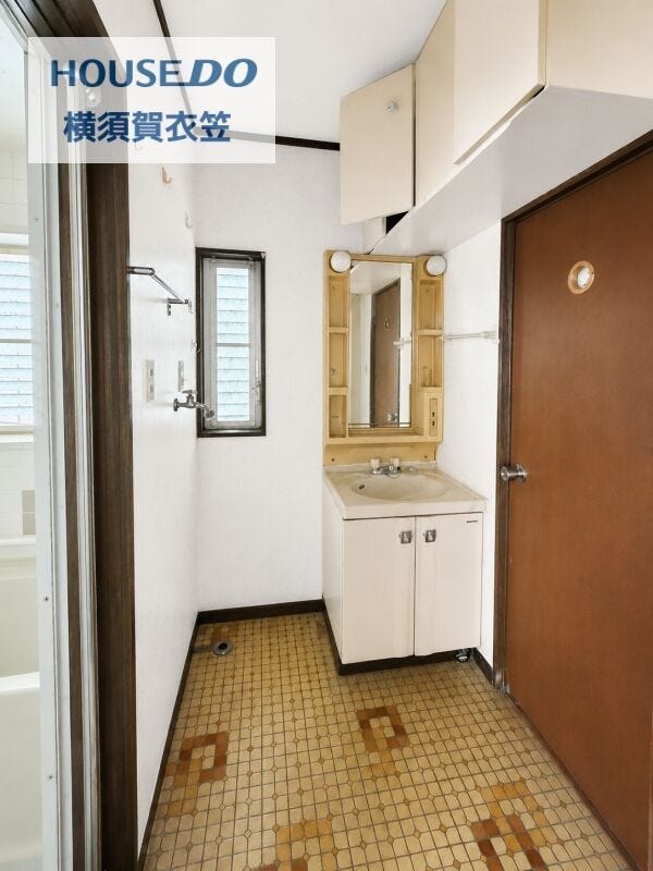 洗面化粧台を備えた洗面室は、縦長窓付きで明るく換気もしやすい空間。洗濯機置場も確保されており、家事動線にも配慮されたつくりです。