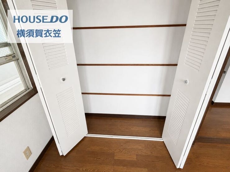 ルーバー扉付きの収納を備えた居室。棚板が複数設けられており、衣類や日用品をすっきり整理しやすい収納スペースです。
