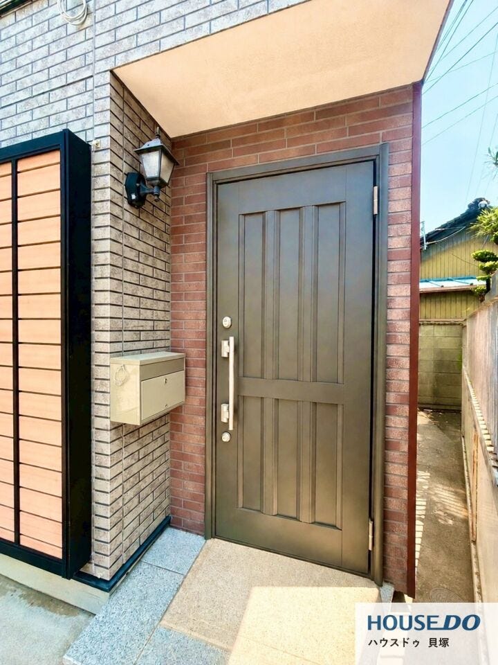 落ち着いた色合いの玄関ドアが上質感を演出。外壁との調和も美しく、住まいの第一印象を引き立てます。