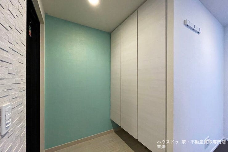 爽やかなアクセントクロスが空間を彩る玄関。帰宅するたびに心地よさを感じる、お洒落な住まいの顔。