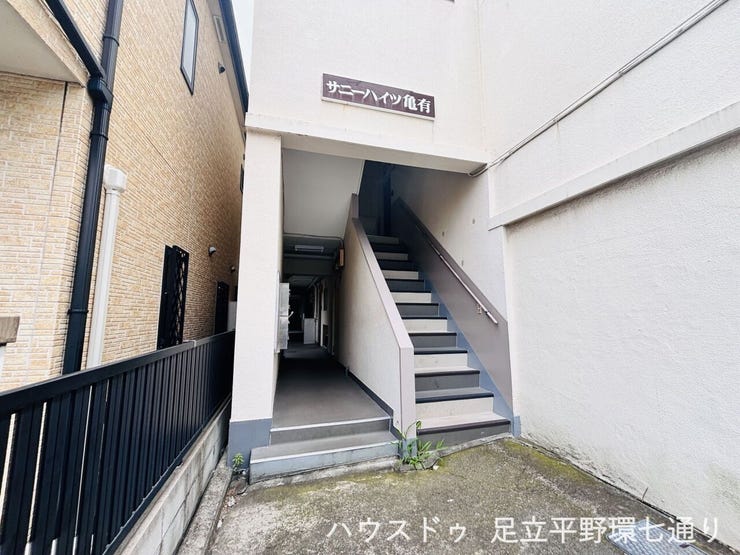 建物入口は階段付きの共用アプローチ。住戸へ向かう動線も分かりやすい造りです。