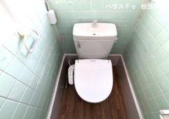 清潔感のある温水洗浄便座付きトイレ。レトロな風合いの床タイルを活かしつつ、便器や手洗いタンクが綺麗に一新されており、レトロモダンな心地よい空間に仕上がっています。