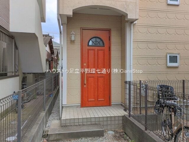 玄関は印象的なオレンジ色の扉を採用。住まいの顔として明るく温かみのある雰囲気を演出します。