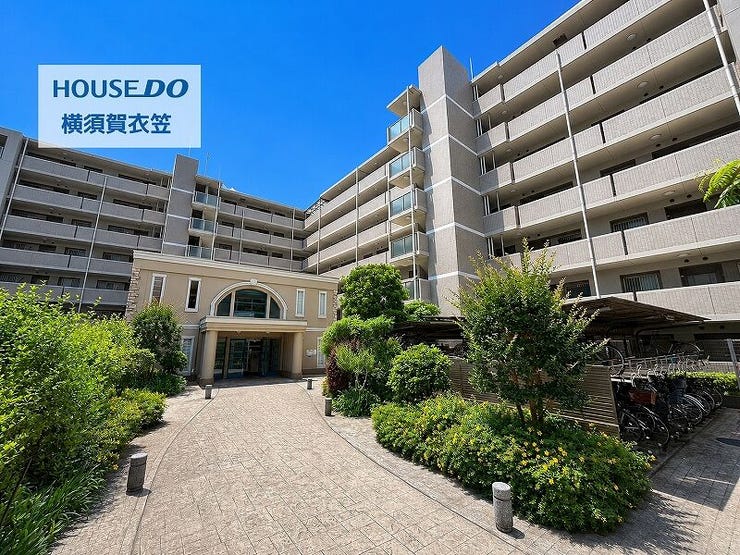 植栽に彩られたアプローチを備えたマンション外観は、重厚感のある佇まいと落ち着いた街並みに調和する上質さが感じられる建物です。