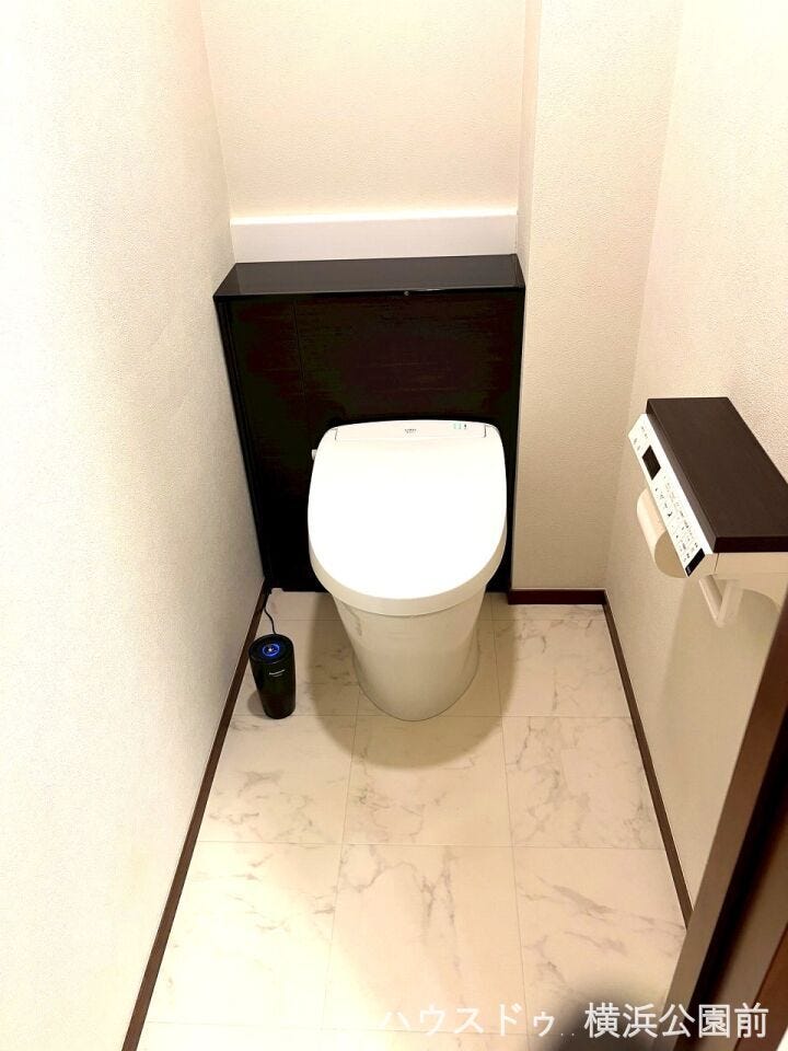 温水洗浄機能付きのタンクレストイレです。ステップも設置されており、トイレ用品をストックしておけます。