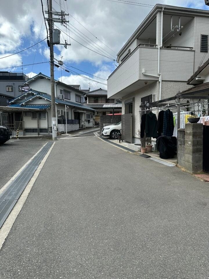 前面道路(2026年3月)撮影、幅員4.3mながら、物件の向かい側は月極駐車場なので圧迫感はなく広々とした立地になります。前面道路も通り抜けの車もなく小さなお子様でも安心です。