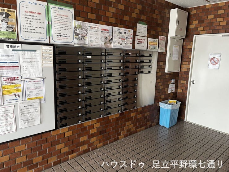 整然と並んだ集合ポストと、居住者への案内が分かりやすく整理された掲示板スペースです。ゴミ箱も設置され綺麗に清掃されており、マンション全体の管理が行き届いていることが一目で分かります。(