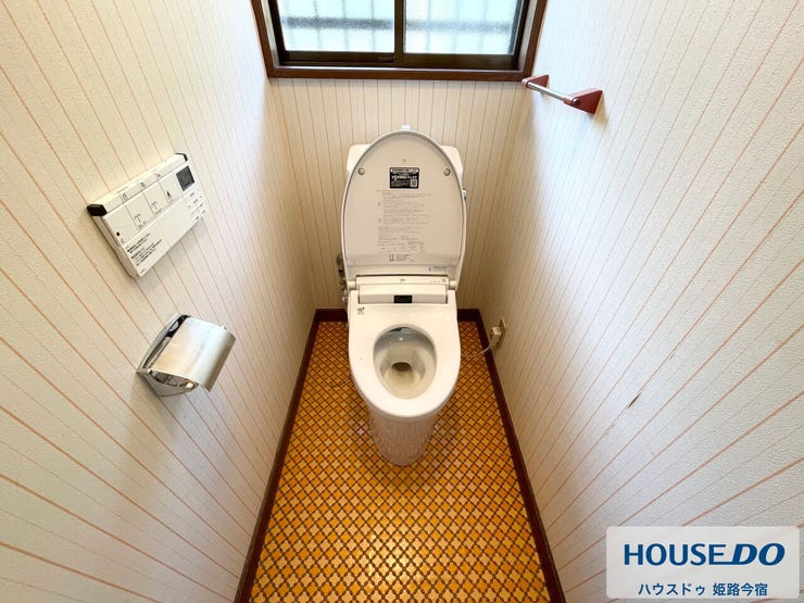 トイレです。手すりと小窓を備えており、白を基調とした内装で清潔感があります。