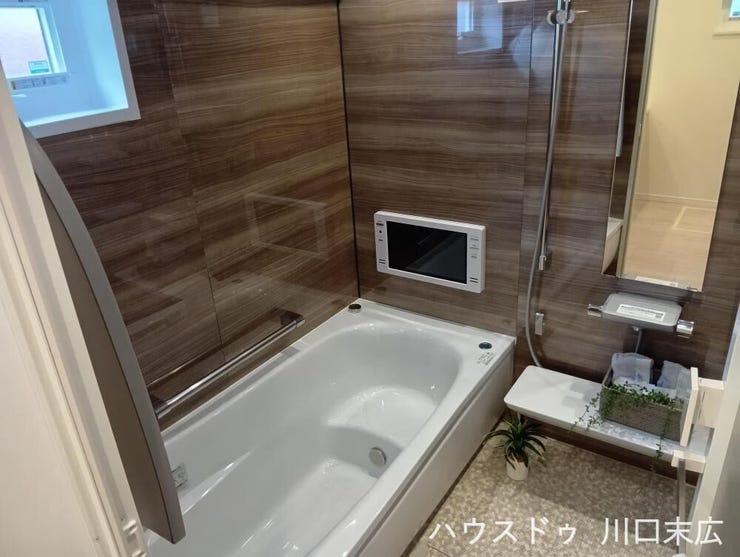木目調のパネルが上質な癒やしを演出するバスルーム。浴室テレビを備えており、一日の疲れをリフレッシュする至福のリラクゼーションタイムを提供します。